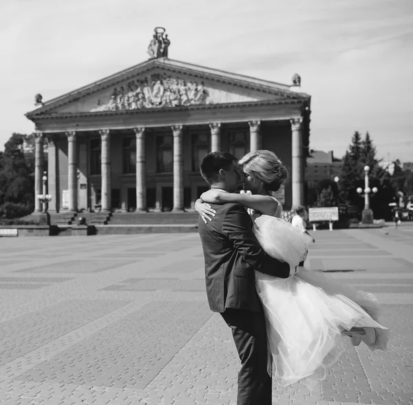 Sposo tiene sposa tra le braccia e contorto — Foto Stock