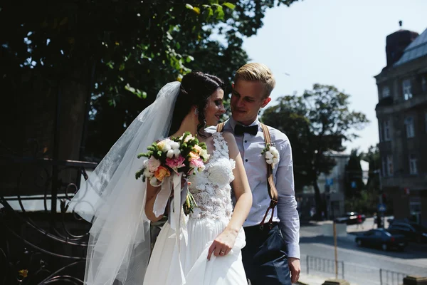 Nevěsta a ženich pózuje na ulicích — Stock fotografie