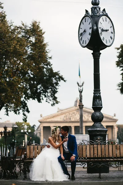 Wedding couple relaxing on a bench — Stock Photo, Image