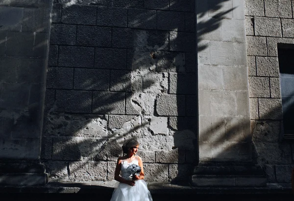 Mariée posant sur fond de mur de pierre — Photo