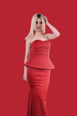 Beautiful fashion model stay in elegant pose, A sexy model in red dress is posing elastically, a cute model staying and looking down lovely