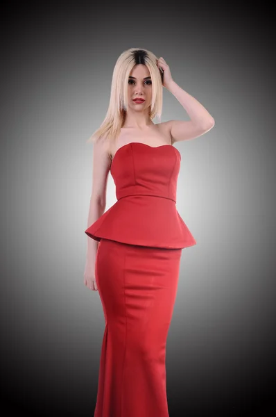 Beautiful fashion model stay in elegant pose, A sexy model in red dress is posing elastically, a cute model staying and looking down lovely