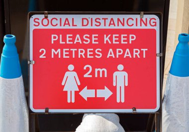 Weston-super-Mare, İngiltere 'de COVID-19 riski nedeniyle yayaları iki metre ayrı tutmaları yönünde bir uyarı işareti.