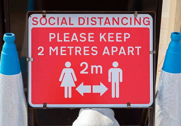 Weston-super-Mare, İngiltere 'de COVID-19 riski nedeniyle yayaları iki metre ayrı tutmaları yönünde bir uyarı işareti.