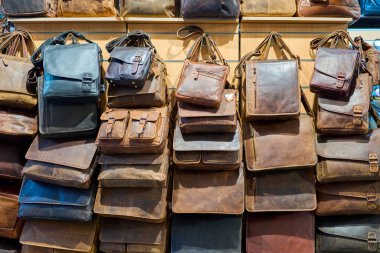Mağaza duvarında asılı eski deri çantalar ve sırt çantaları. Perakende sektöründe kahverengi ve koyu deri aksesuarların şık bir çeşidi, vitrin işçiliği, moda yaşam tarzı ve klasik günlük tasarım..