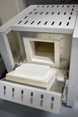 Seramik yalıtım odalı açık bir laboratuvar susturucu fırınının yakın çekimi. Kimyasal ve malzeme laboratuvarlarında yüksek sıcaklıkta ısı tedavisi, kalsinasyon ve termal analiz için kontrollü koşullarda kullanılır..