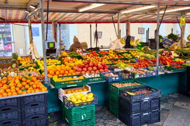 Kutularda taze meyve ve sebzelerle dolu açık hava tezgahı. Doğal gıda ürünleri ve mevsimlik ürünlerle kentsel pazar sahnesi.