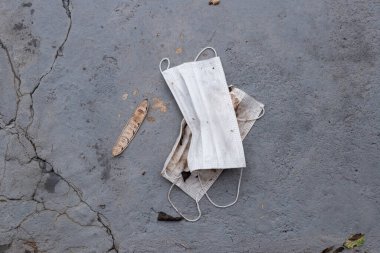 Beyaz Covid-19 koruyucu maskeler sokakta uygunsuz bir şekilde yok edildi..