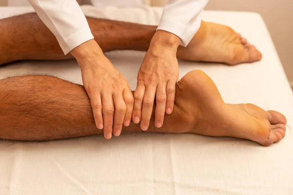 Terapeut Provádí Masáž Nohou Pacientovi Který Leží Nosítkách — Stock fotografie