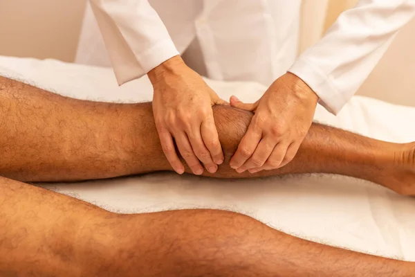 Terapeuta Fazendo Massagem Nas Pernas Para Paciente Que Está Deitado — Fotografia de Stock