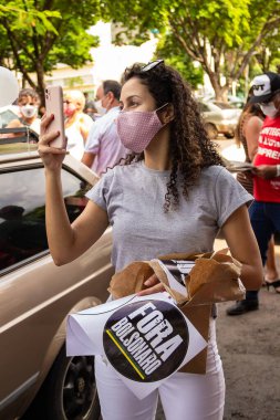 Bolsonaro 'nun görevden alınması için gösteri çağrısı. Selfie çeken ve elinde yazılı işaret olan kız: Bolsonaro çıktı!