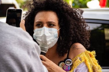 Başkan Bolsonaro 'nun görevden alınmasını talep eden bir protestoda maskeli bir kadın sorguya çekiliyor..