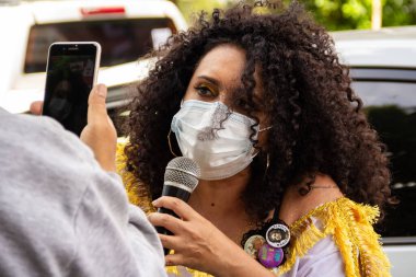 Başkan Bolsonaro 'nun görevden alınmasını talep eden bir protestoda maskeli bir kadın sorguya çekiliyor..