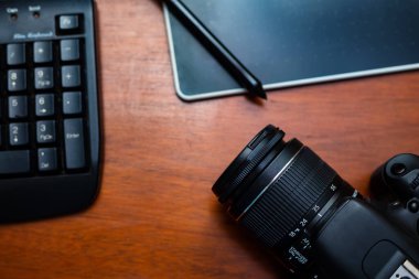 Bir fotoğraf makinesi, bir klavye ve ahşap bir masanın dijital tablosu..