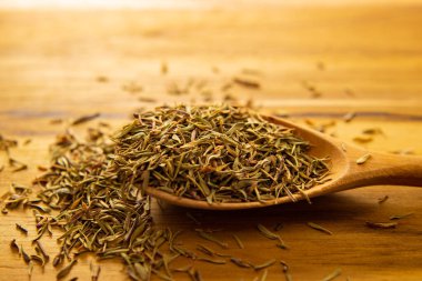 Masanın üzerinde kurumuş kekik dolu tahta bir kaşık..