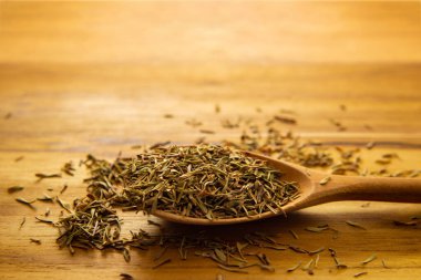 Masanın üzerinde kurumuş kekik dolu tahta bir kaşık..