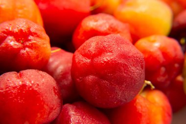 Soğutulduktan sonra ıslanan olgun aseroller yığınına yaklaş..