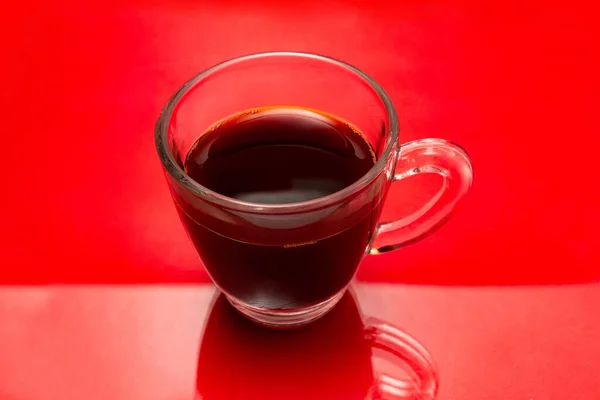 Una Taza Vidrio Transparente Con Café Sobre Una Superficie Roja — Foto de Stock