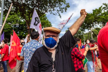Yumruğu havada yaşlı bir adam. Fotoğraf, Brezilya Başkanı Bolsonaro 'ya karşı yapılan bir protesto sırasında çekildi ve nüfusu aşılamak için aşı satın almada çeviklik talep ediliyor..