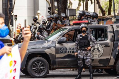 Protesto için güvenliği sağlayan polis birlikleri; Brezilya Cumhurbaşkanı Bolsonaro 'ya karşı düzenlenen bir protesto sırasında çekilen fotoğraf ve nüfusu aşılamak için aşı satın almada çeviklik talebi.