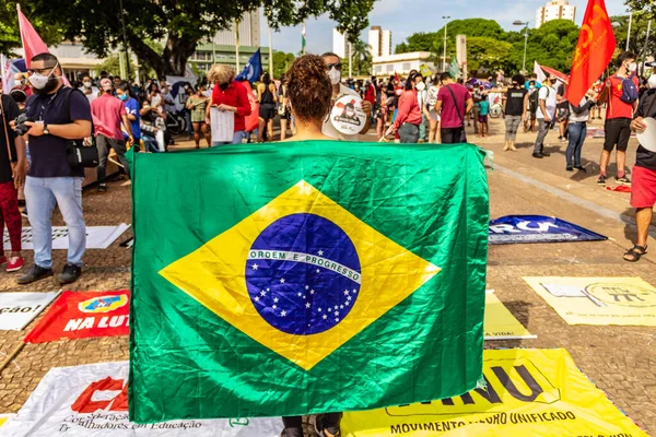 ブラジルの国旗を掲げる女性が抗議している ブラジル大統領 ボルソナーロに対する抗議中に撮影され 人口を予防するためのワクチンの購入の敏捷性を求めています — ストック写真