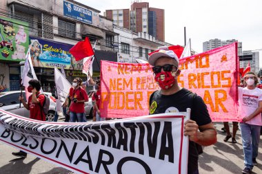 Koruyucu maskeler takan ve pankart ve posterler taşıyan protestocular. Protesto; Brezilya Cumhurbaşkanı Bolsonaro 'ya karşı düzenlenen bir protesto sırasında çekilen fotoğraf ve nüfusu bağışık hale getirmek için aşı satın almada çeviklik istenmesi.