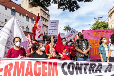 Koruyucu maskeler takan ve pankart ve posterler taşıyan protestocular. Protesto; Brezilya Cumhurbaşkanı Bolsonaro 'ya karşı düzenlenen bir protesto sırasında çekilen fotoğraf ve nüfusu bağışık hale getirmek için aşı satın almada çeviklik istenmesi.
