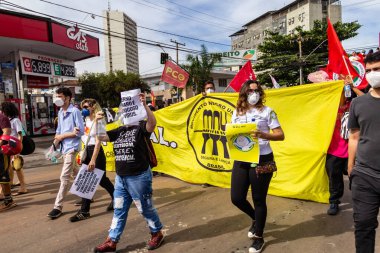 Protestocular ellerinde pankart, poster ve bayraklar tutan maskeler takıyorlar. Protesto; Brezilya Cumhurbaşkanı Bolsonaro 'ya karşı düzenlenen bir protesto sırasında çekilen fotoğraf ve nüfusu bağışık hale getirmek için aşı satın almada çeviklik istenmesi.