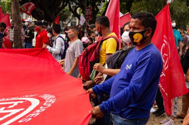 Protestocular ellerinde pankart, poster ve bayraklar tutan maskeler takıyorlar. Protesto; Brezilya Cumhurbaşkanı Bolsonaro 'ya karşı düzenlenen bir protesto sırasında çekilen fotoğraf ve nüfusu bağışık hale getirmek için aşı satın almada çeviklik istenmesi.