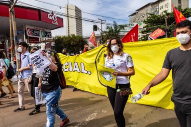 Protestocular ellerinde pankart, poster ve bayraklar tutan maskeler takıyorlar. Protesto; Brezilya Cumhurbaşkanı Bolsonaro 'ya karşı düzenlenen bir protesto sırasında çekilen fotoğraf ve nüfusu bağışık hale getirmek için aşı satın almada çeviklik istenmesi.