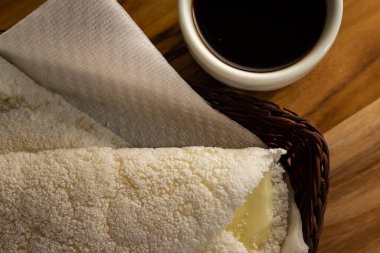 Masada bir fincan kahveyle küçük bir sepetin içine tıkıştırılmış iki tapyoka. Tapyoka - nişastandan yapılmış tipik Brezilya yemeği.