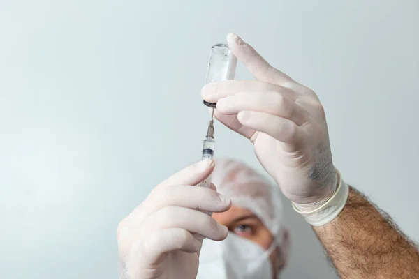 Bir doktor şırıngayı ilaçla hazırlıyor. Şırınga ile covid-19 aşısı.