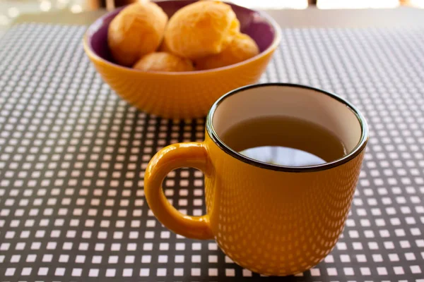 Ein Becher Tee Mit Einer Schüssel Käsebrötchen Auf Einem Schwarz — Stockfoto