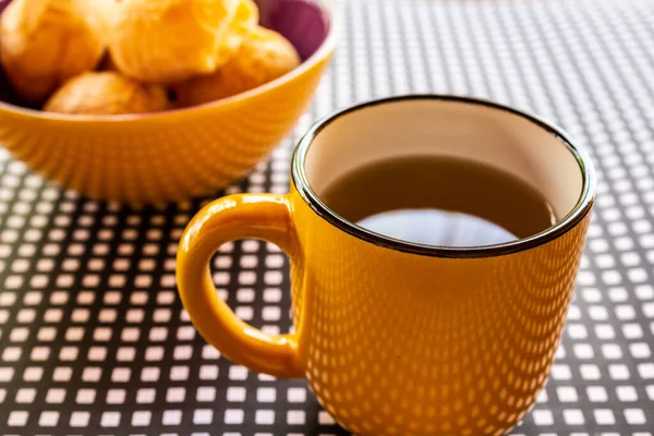 Ein Becher Tee Mit Einer Schüssel Käsebrötchen Auf Einem Schwarz — Stockfoto