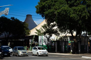 Goiania şehir merkezindeki Avenida Paranaiba 'daki açık hava pazarının ayrıntıları ağaçlar arasında görülüyor. Peyzaj biçiminde renkli resim.