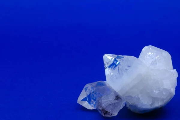 crystals of white transparent quartz on a blue background