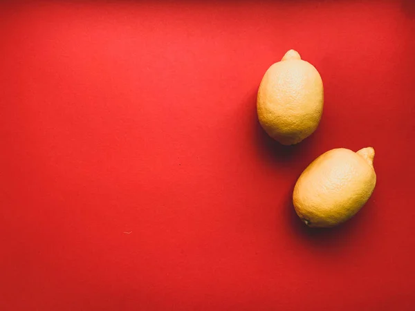 Due Limoni Gialli Fondo Rosso Limone Foto Dall Alto Vitamina — Foto Stock