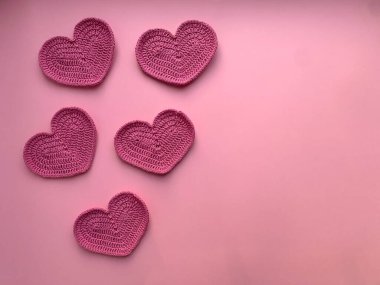 Pembe arka planda pembe kalpler ördüm. Fotoğraf yukarıdan. Ürün yaratma kavramı. Tığ işi. Sevgililer Günü konsepti