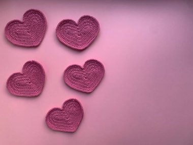 Pembe arka planda pembe kalpler ördüm. Fotoğraf yukarıdan. Ürün yaratma kavramı. Tığ işi. Sevgililer Günü 