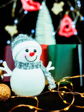 Yılbaşı fotoğraflarında bir kardan adam, çelenk, arka planda farklı renklerde deri cüzdanlar. Şenlik havası. Kartpostal için resim. İndirim, satış..