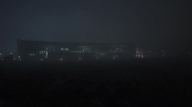 Modern araştırma merkezi binası gece sisi altında.