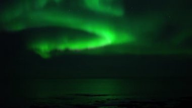 Sakin okyanus suyuna yansıyan gerçek zamanlı Aurora Borealis.