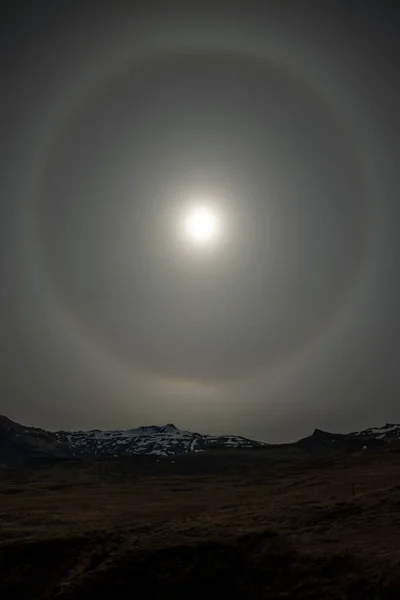 Sun halo over mountains in Iceland vertical
