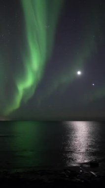 Aurora borealis ve ay okyanusa, İzlanda 'ya, dikey görünüm oranına yansıyor.