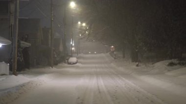 ABD sokak ışıklarında parlayan küçük bir kasabada, boş bir caddeye kar yağıyor. Yüksek kalite 4k görüntü