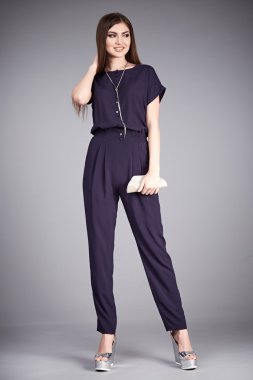 Güzel, seksi bir kadın yürüyüş, ipek bluz, pamuk pantolon, yüksek topuklu ayakkabılar stüdyo aksesuarları, uzun esmer saçlar, doğal makyaj çantası.