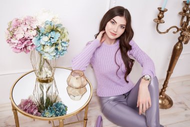 Mükemmel ev eşyaları içinde güzel bir kadın mum kız günlük moda süveter tarzı pantolonlar ve ayakkabı giyer ofis yürüyüşü için doğal makyaj ve seksi vücut makyajı yapar. 