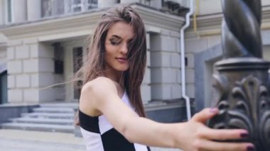 Kameranın açık omuz akşam makyaj saç sıcak yaz esintiyle sallanan ile moda elbise genç zarif kadın geldi yavaşça döndü flört bir tarihte dışarı bakar