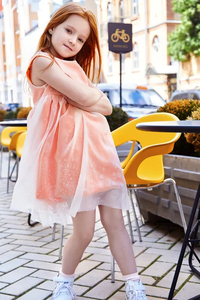 Kleines Mädchen trägt pfirsichfarbenes Modekleid — Stockfoto