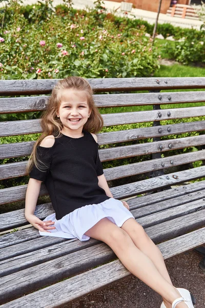 Küçük kız güzel yüz güzel çocuk bankta oturan — Stok fotoğraf